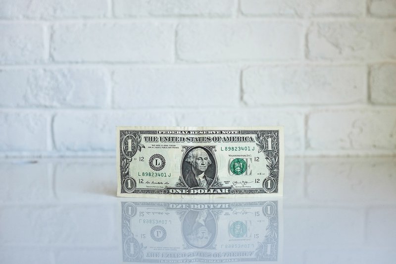 One dollar bill by the wall